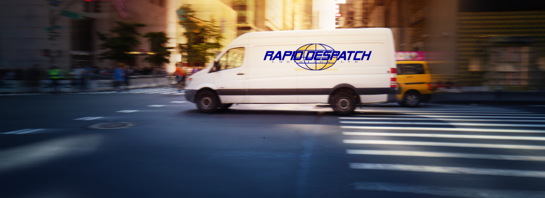 A white Rapid Despatch van driving through a city street