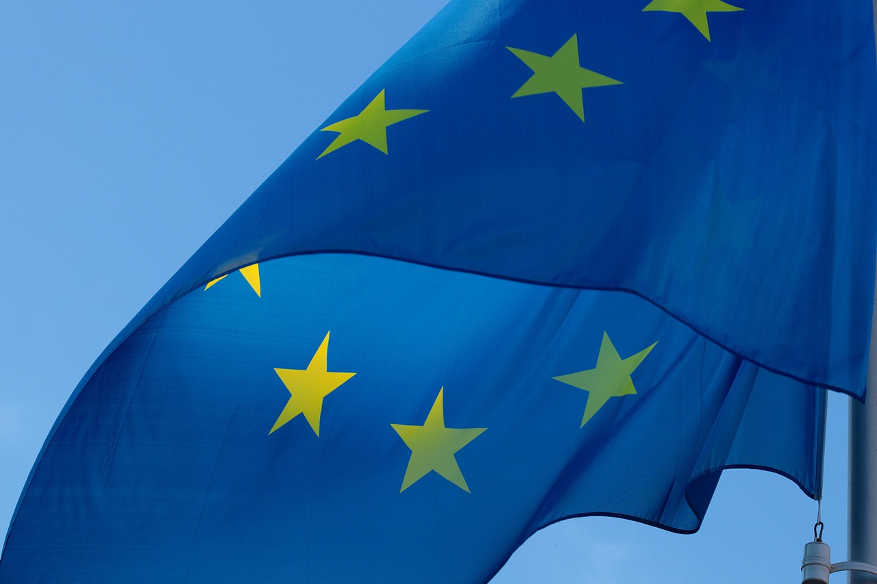 An EU flag waving against a blue sky