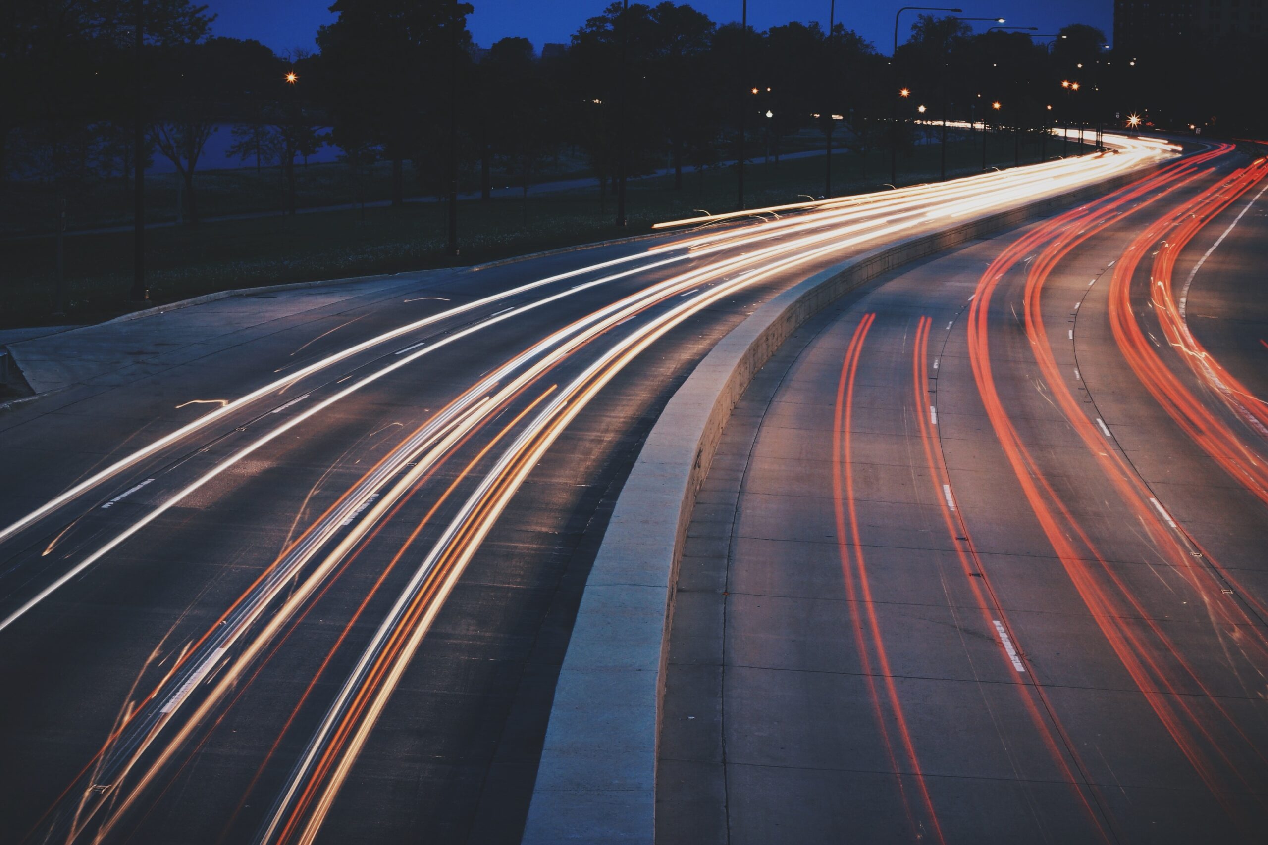 Light trails from traffic on a curving road at night