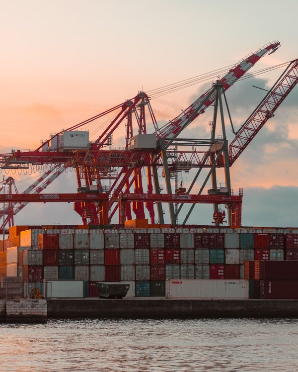 Container cranes and stacked containers at a port at dusk