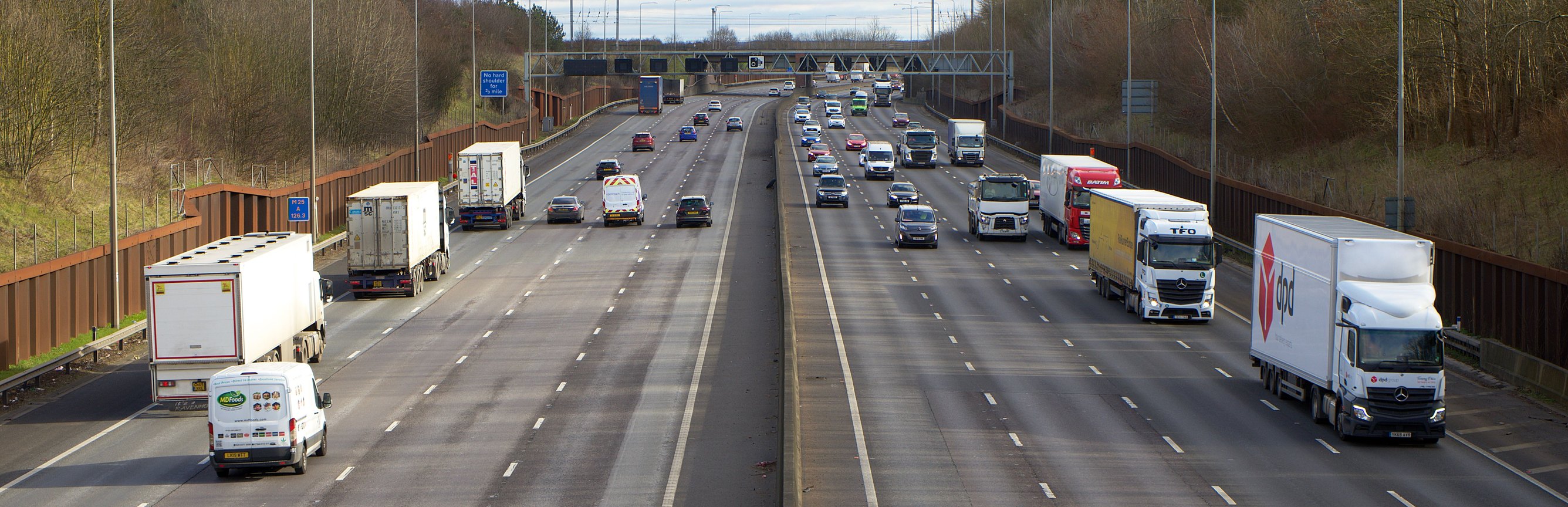 Vans and lorries on a busy UK motorway seen from above