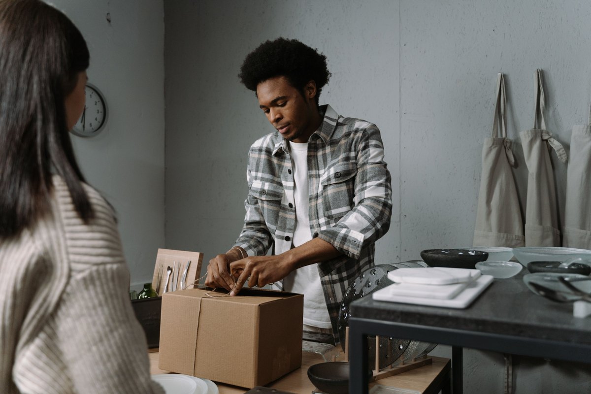 A shop worker carefully packing a box