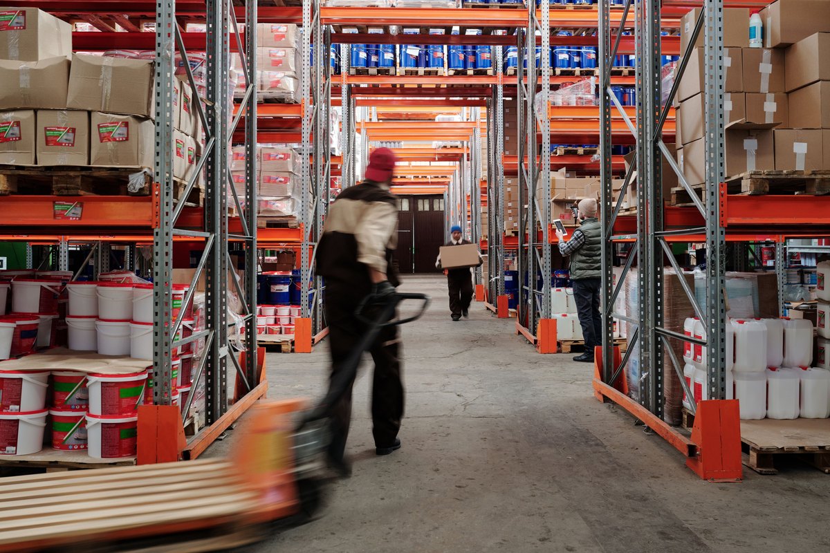 A busy warehouse interior with workers moving stock
