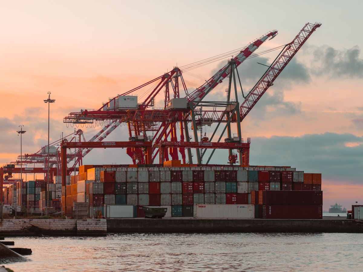 Container cranes and stacked containers at a port at dusk