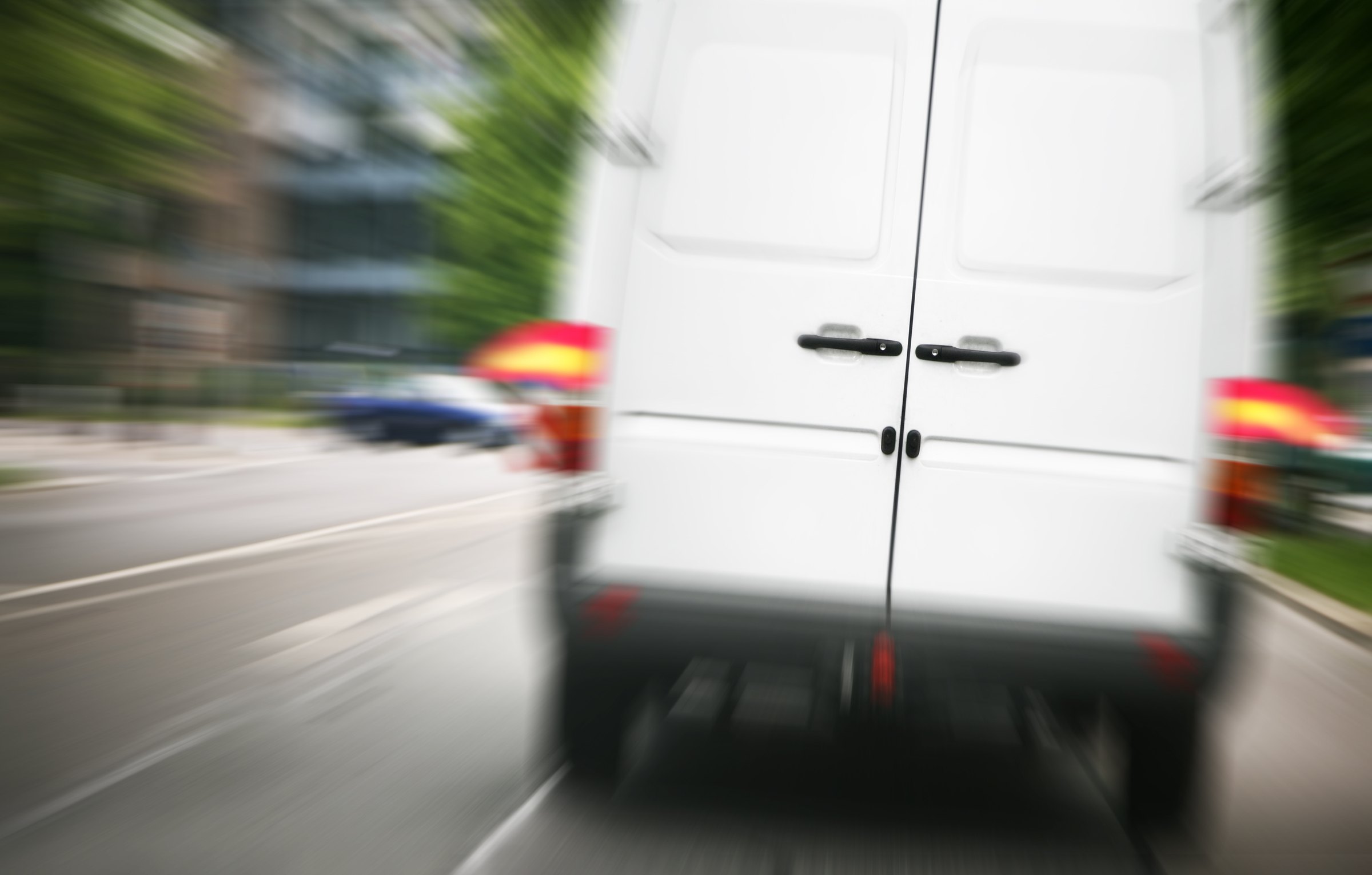 A courier van moving at speed on a road