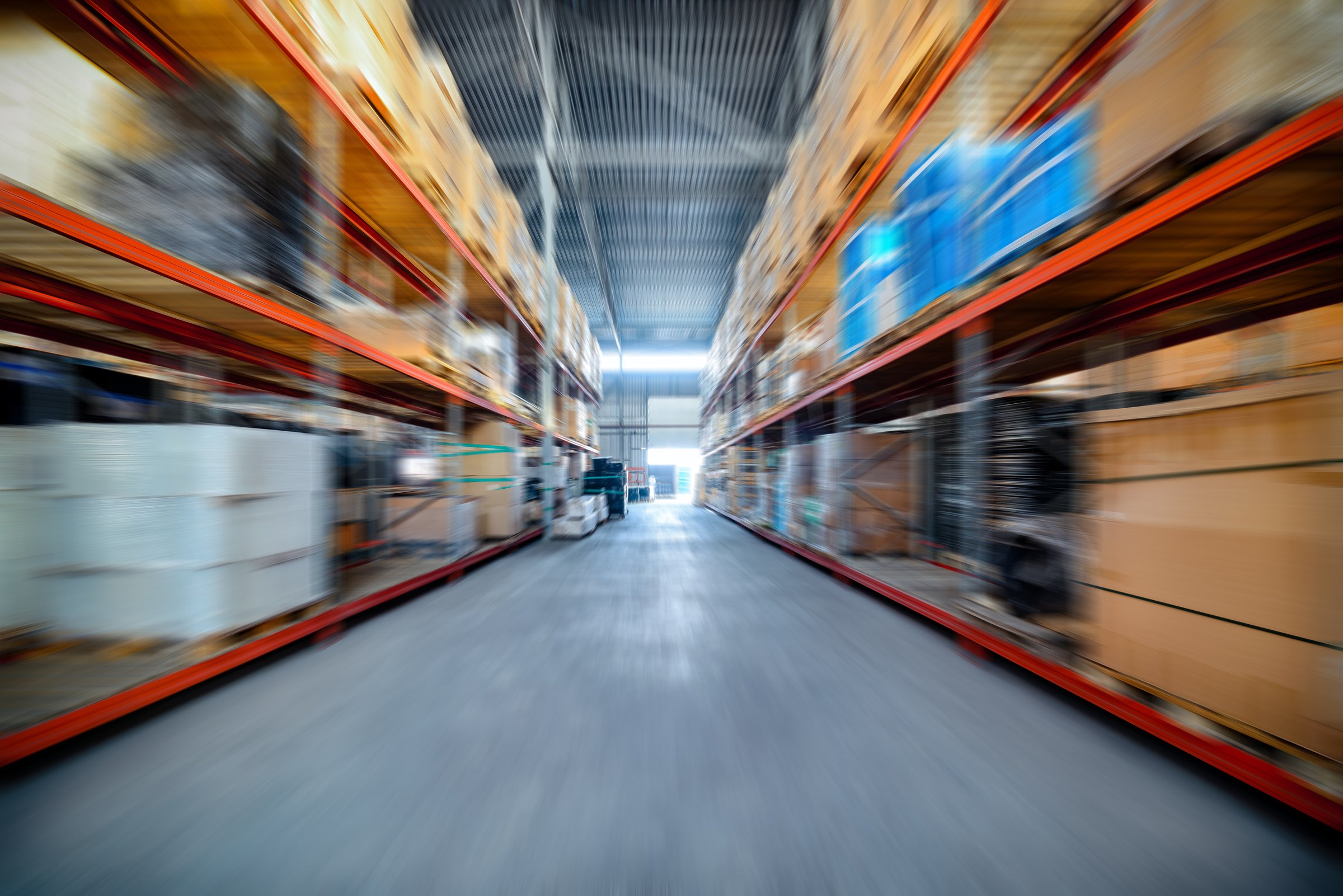 Stock on warehouse racking down a long aisle