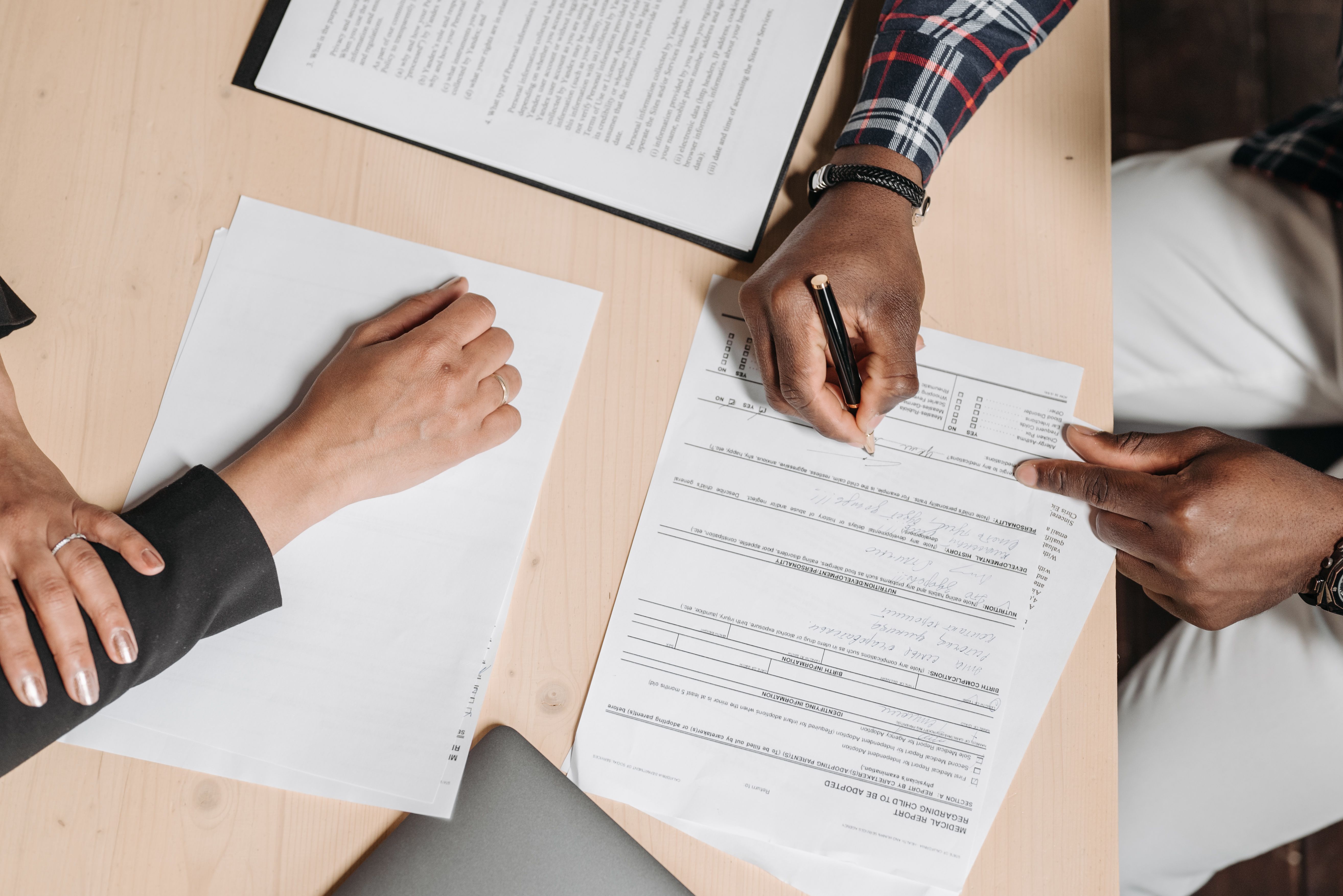 Two people at a desk signing a business account application