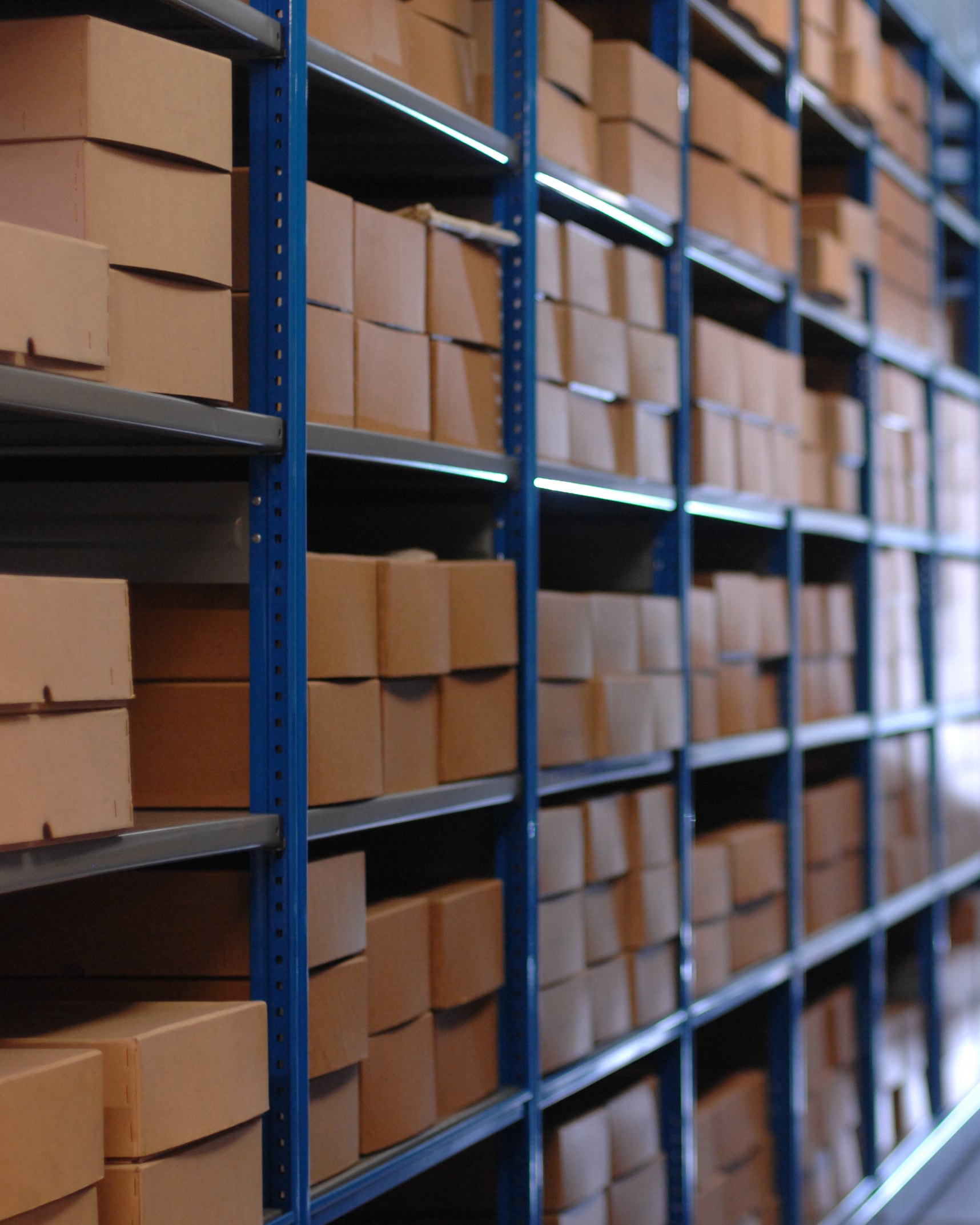 Boxed stock on warehouse racking down a long aisle