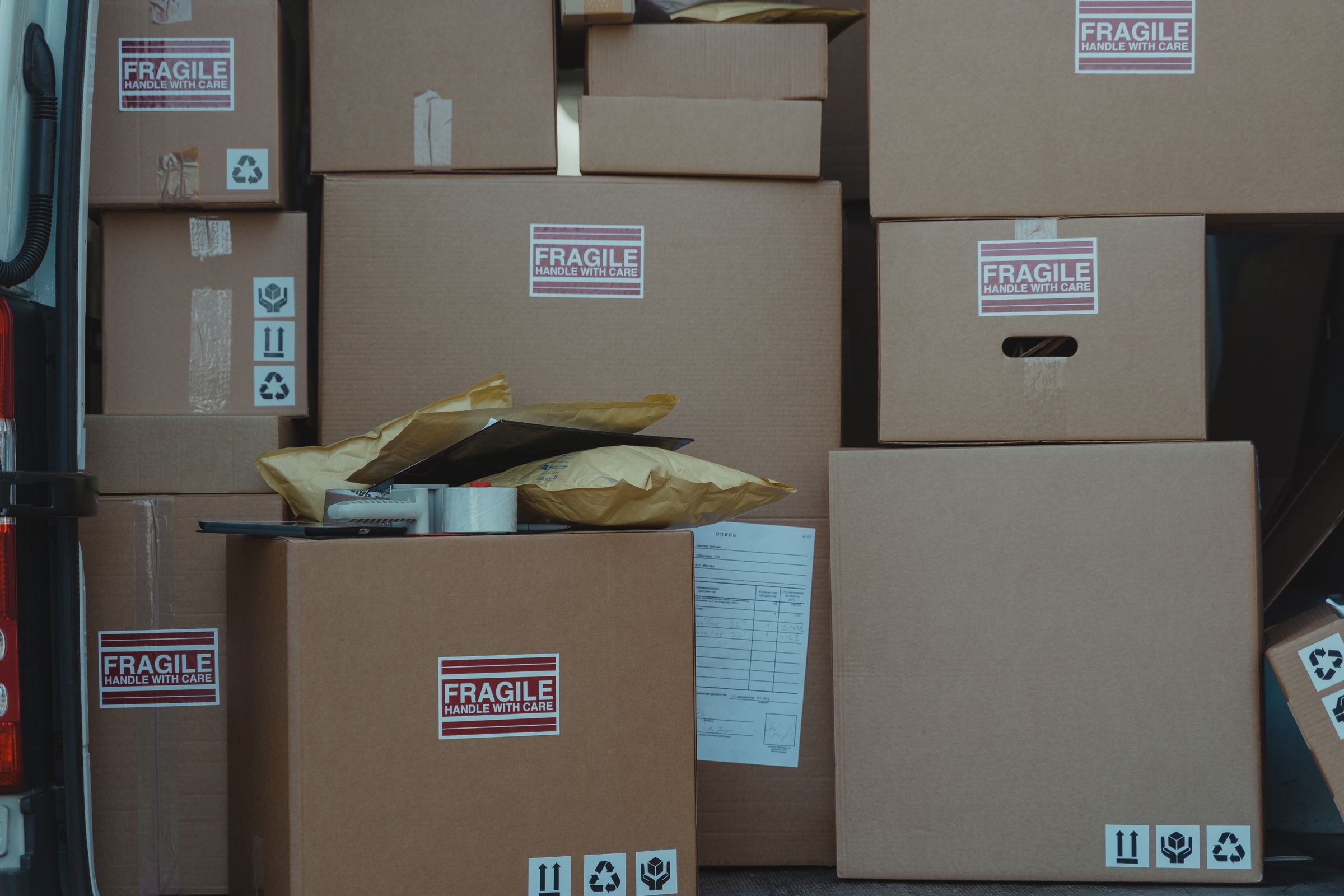 Boxes marked fragile loaded into a van with their paperwork
